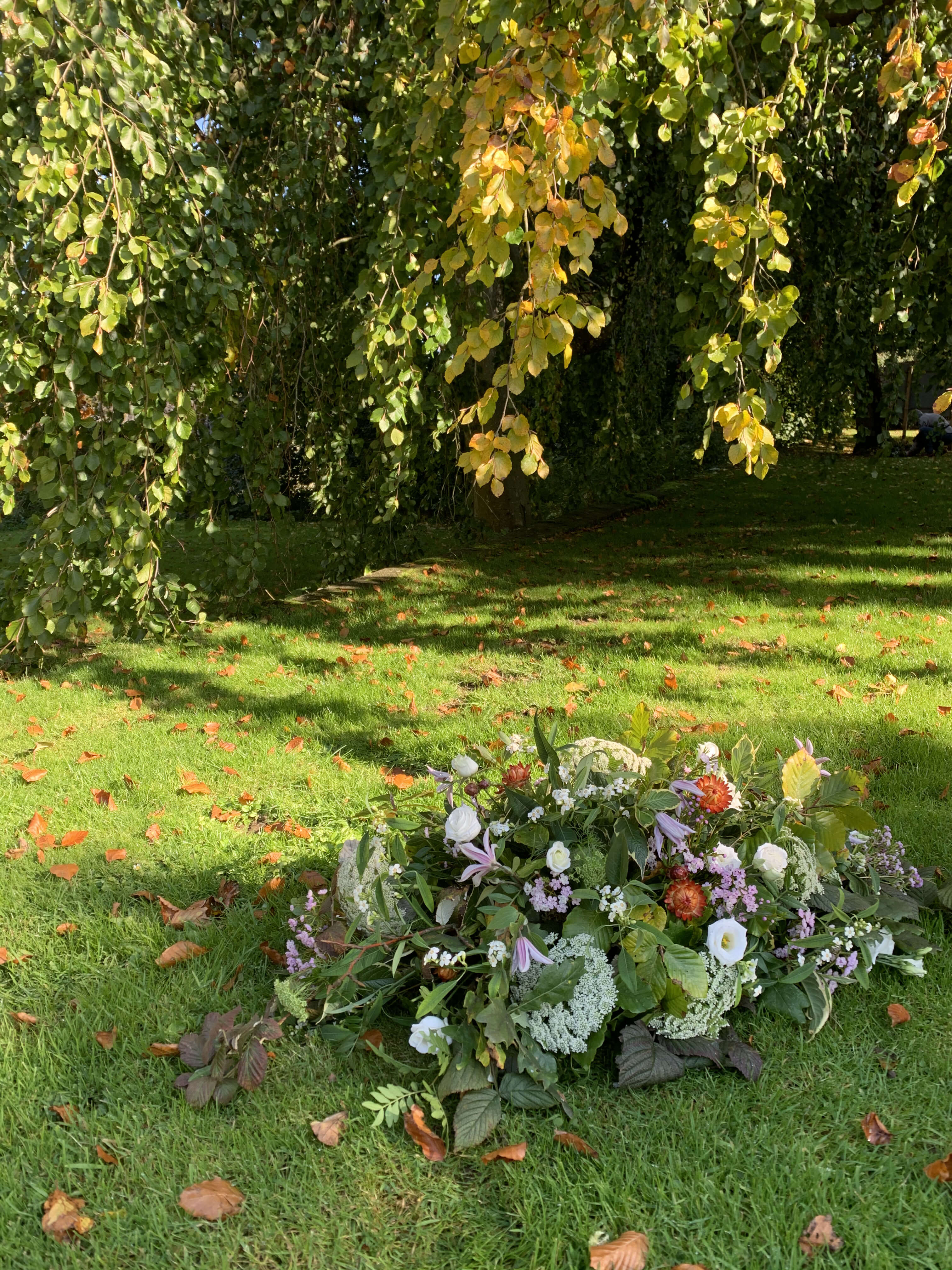 Funeral Floral arrangement on a grassy area with trees in the background