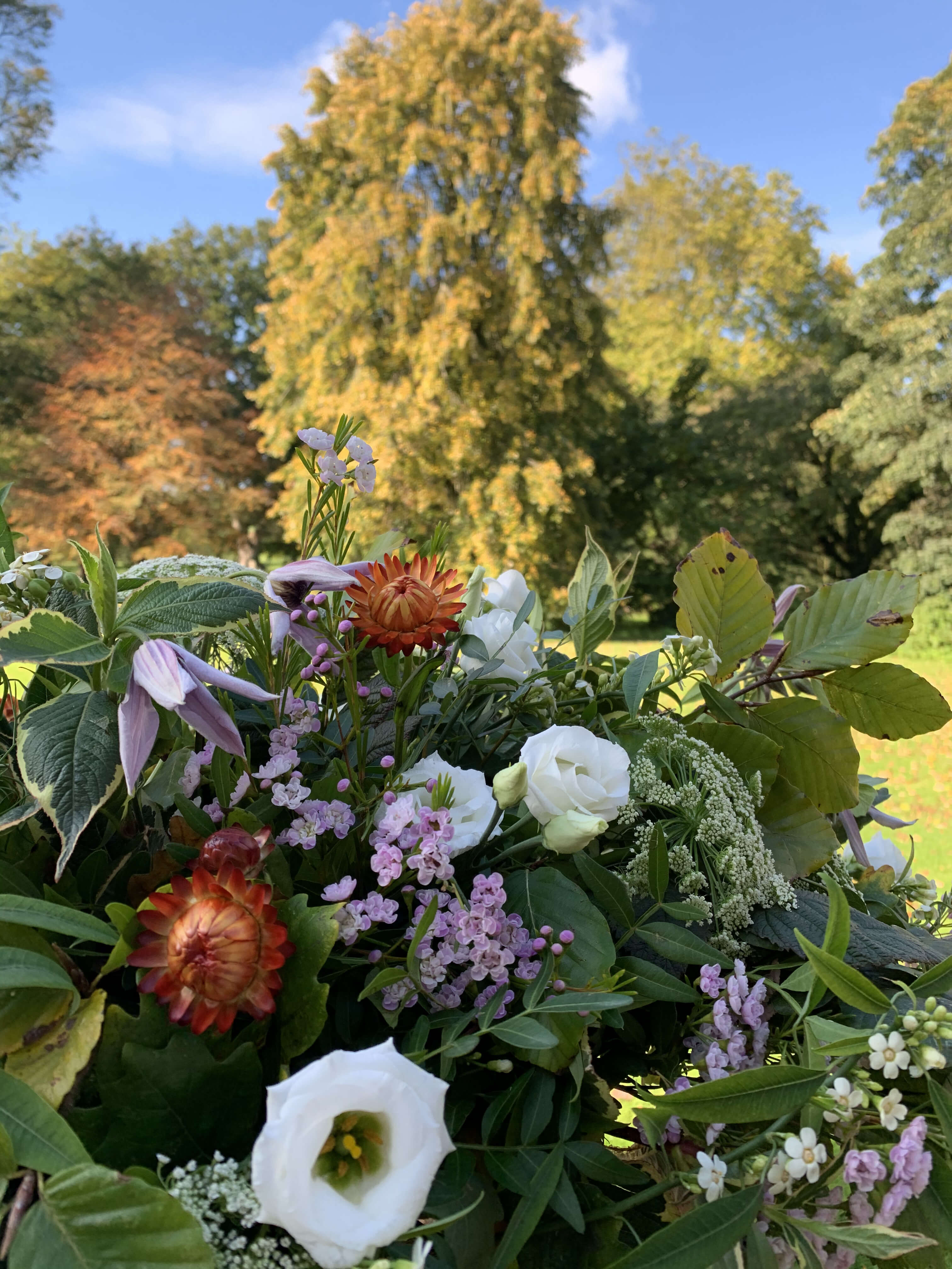 Bouquet of farewell flowers with greenery against a natural background